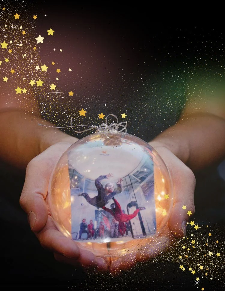 Two hands offering an ornament gift revealing the iFLY tunnel flight experience